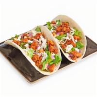Korean Tacos · Spicy chicken or marinated ribeye over two flour tortillas. Topped with lettuce, coleslaw, b...