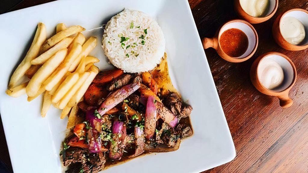 LOMO SALTADO · Sauteed grass fed filet mignon strips with onions, tomatoes, french fries served with rice