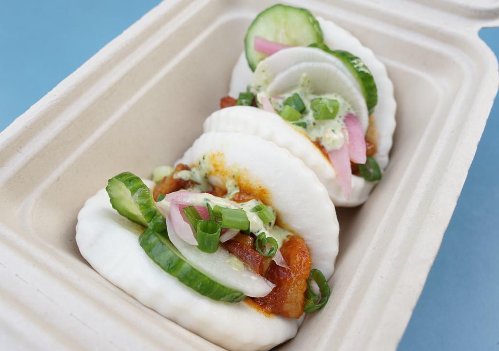 Bellyrub Bao Bao · Our delicious smoked pork belly stuffed inside steamed Bao Buns topped with Cucumber Salad, Gochu BBQ sauce, Aji Verde, and Green Onions.