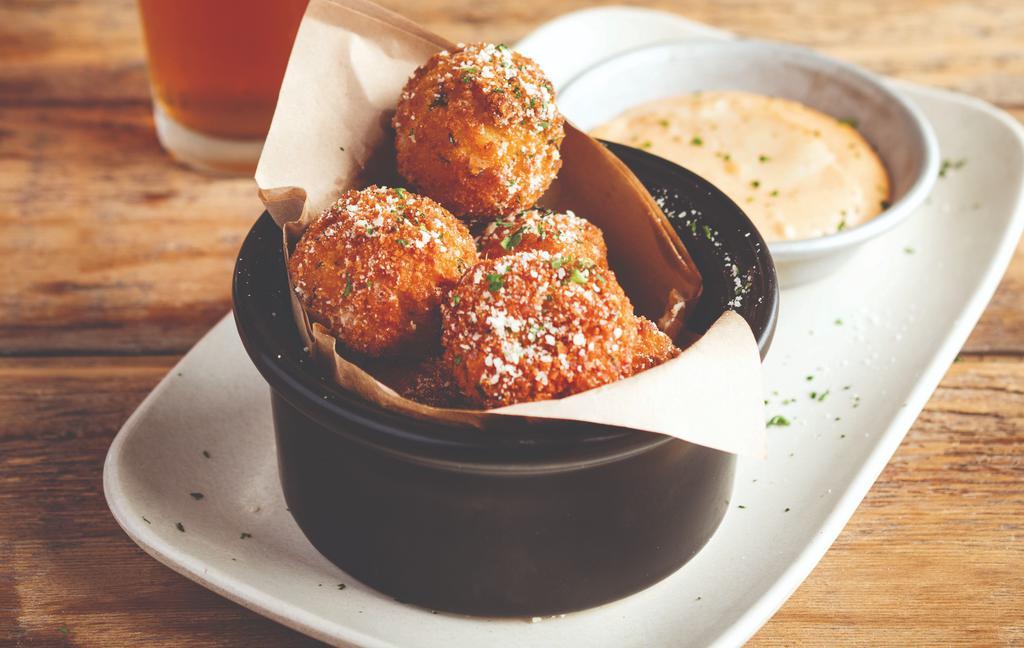 Mac 'n Cheese Bites · Pasta shells and spiced pepper jack cheese sauce, coated in bread crumbs, and fried crispy. Served with our sriracha-lime aioli and chopped cilantro.