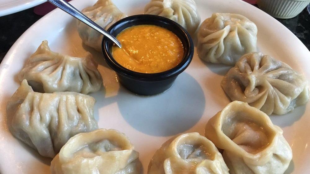 Veg. Momo (8 Pieces) · Vegan. Steamed dumplings filled with minced cabbage, spinach, mushroom, cashew nuts, cheese, onion, and cilantro. Served with tomato chutney.