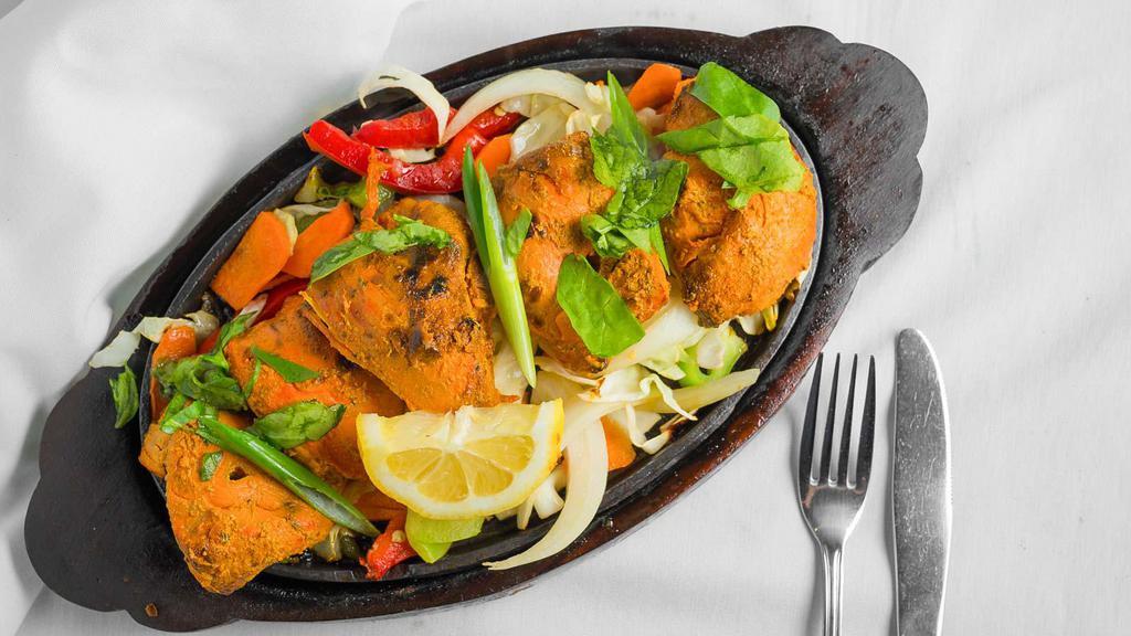 #55. Chicken Tandoori · Chicken marinated in yogurt and spices, broiled in the tandoor oven and served sizzling with sauteed onions, bell peppers, cabbage and carrots.