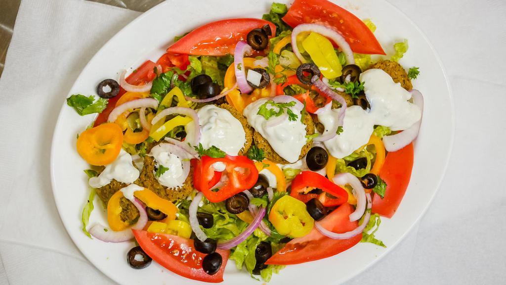 FALAFEL  SALAD · Falafel Balls  .Lettuce, tomatoes, onions, sliced olives, cucumbers, peppers, carrots  tzatziki sauce, olive oil . balsamic vinegar  &  pita  bread