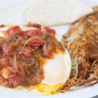 Huevos Rancheros · Eggs covered with fresh salsa on a tortilla topped with vegetarian refried beans and cheese ...