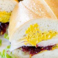 Turkey & Cranberry Sandwich · Includes mayonnaise, mustard, lettuce, tomato, pickle, onion and our sun-dried tomato tapena...