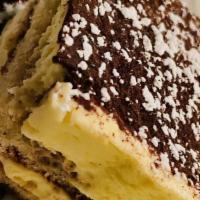 Tiramisu · Two layers of espresso drenched sponge cake divided by mascarpone cream and dusted with coco...