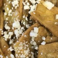 Chilaquiles · Tortilla chips cooked with red or green sauce, topped with cheese and sour cream, served wit...