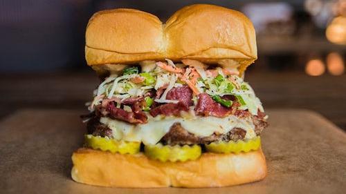 The Mensch · White American cheese, pickles, pastrami, Haus slaw, secret sauce.