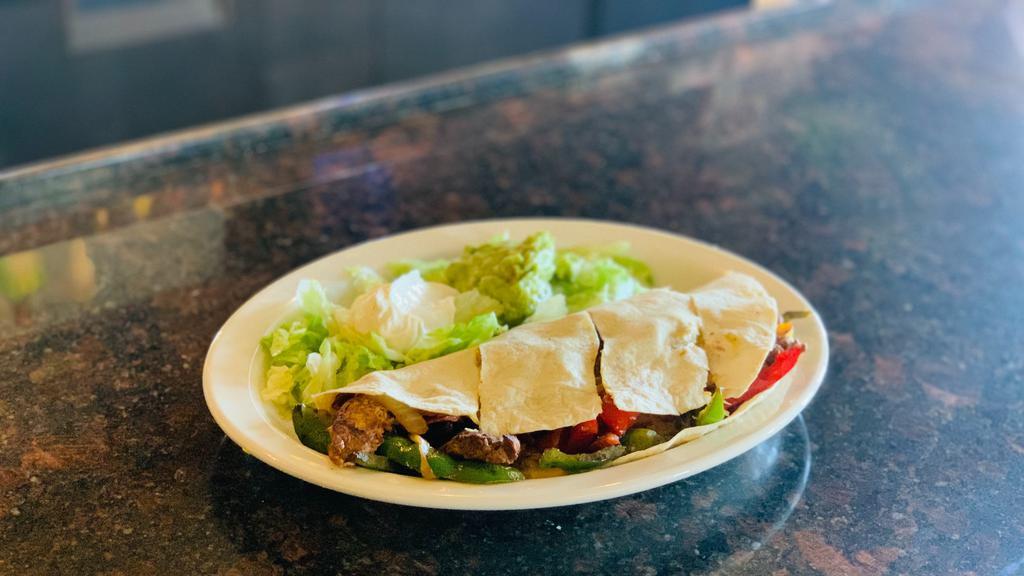 Fajita Quesadillas · A giant our tortilla filled with cheese, sautéed onions, bell peppers, carrots, and your choice of chicken, steak or a combination of both. Served with lettuce guacamole and sour cream on top.