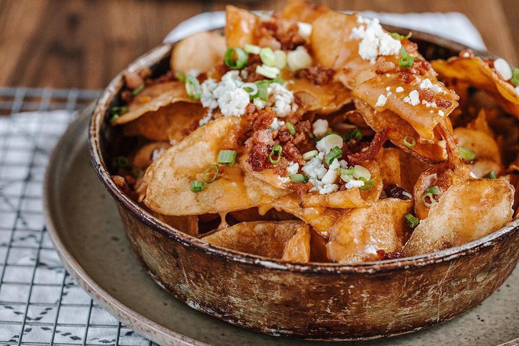 Kettle Nachos · Kettle chips, brewery queso, bacon, green onion, blue cheese.