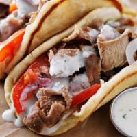 Lucious Halal Lamb Gyro · Thick and fluffy pita bread filled with thin flavorful slices of lamb, grilled tomatoes and ...