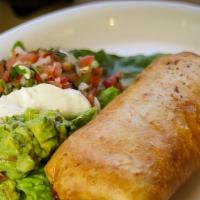 Chimichanga $12 · A fried flour tortilla stuffed with Mexican rice, refried beans, shredded chicken with a sid...