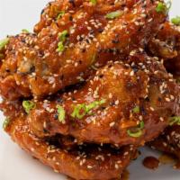 Korean Fried Chicken Wings · Double fried chicken wings glazed in spicy gochujang, wildflower honey and toasted sesame
