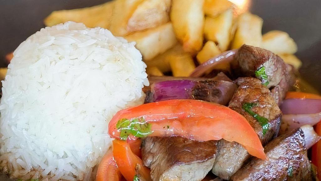 Lomo saltado · Traditional Peruvian style beef tenderloin, red onion, tomatoes, cilantro, garlic, soy and oyster sauce, french fries & rice.