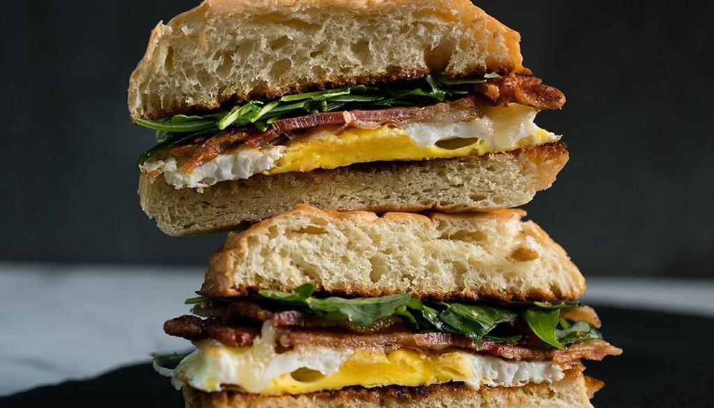 FRIED EGG SANDWICH · Two pasture eggs, aged cheddar, and arugula, on a grilled challah bun.