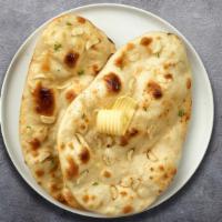 The Great Garlic Naan · Freshly baked bread in a clay oven garnished with garlic and butter