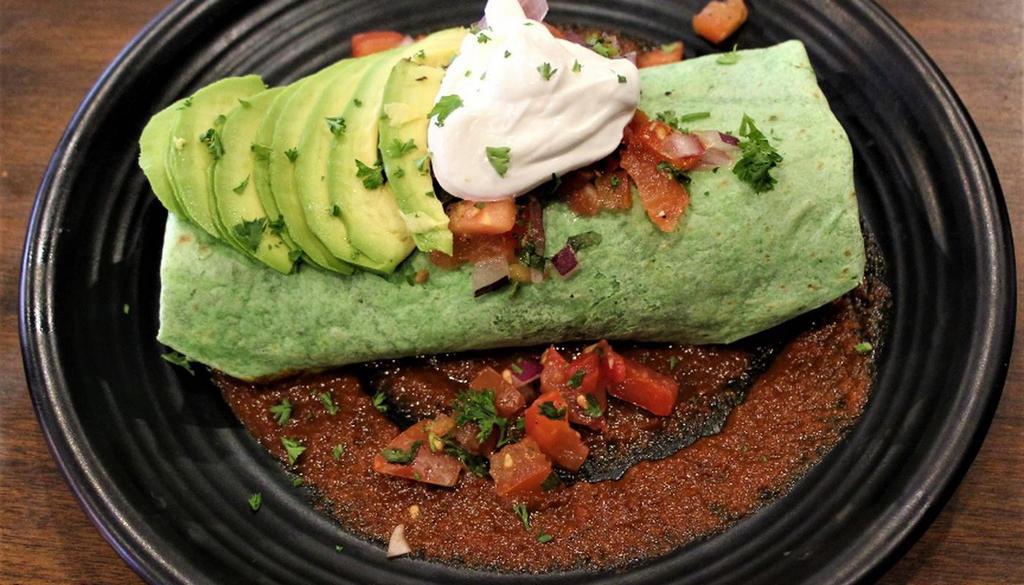 Breakfast Burrito · CHEDDAR AND PEPPER JACK CHEESE, BLACK BEANS, SCRAMBLED EGGS, CHORIZO, PICO DE GALLO AND SOUR CREAM ON A BED OF RANCHERO SAUCE WRAPPED IN SPINACH TORTILLA.