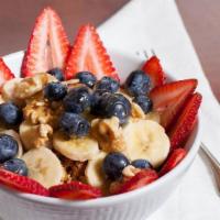 Granola & Yogurt · HOMEMADE GRANOLA TOPPED WITH STRAWBERRIES, BLUEBERRIES AND BANANAS WITH A DRIZZLE OF HONEY.