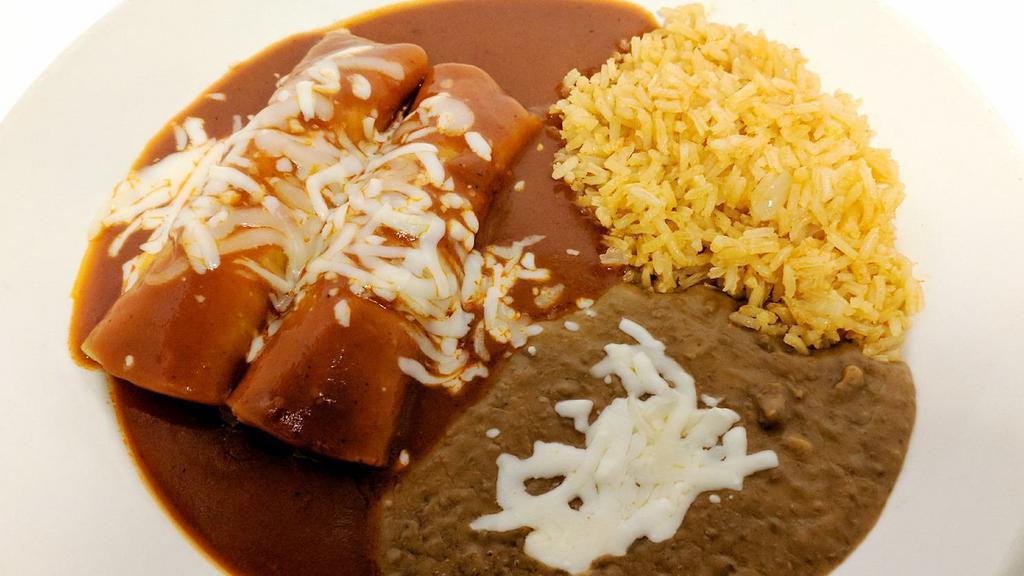 2. Cheese Enchilada Plate · Two cheese enchiladas topped with home made mole and cheese with a side of rice and beans.