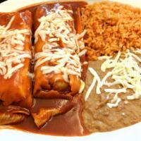 11. Tamal Plate · Two home made tamales topped with mole and cheese with rice and beans.