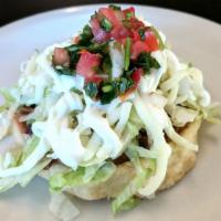 Sope · Hand made thick tortilla topped with refried beans, meat, lettuce, cheese, guacamole, sour c...