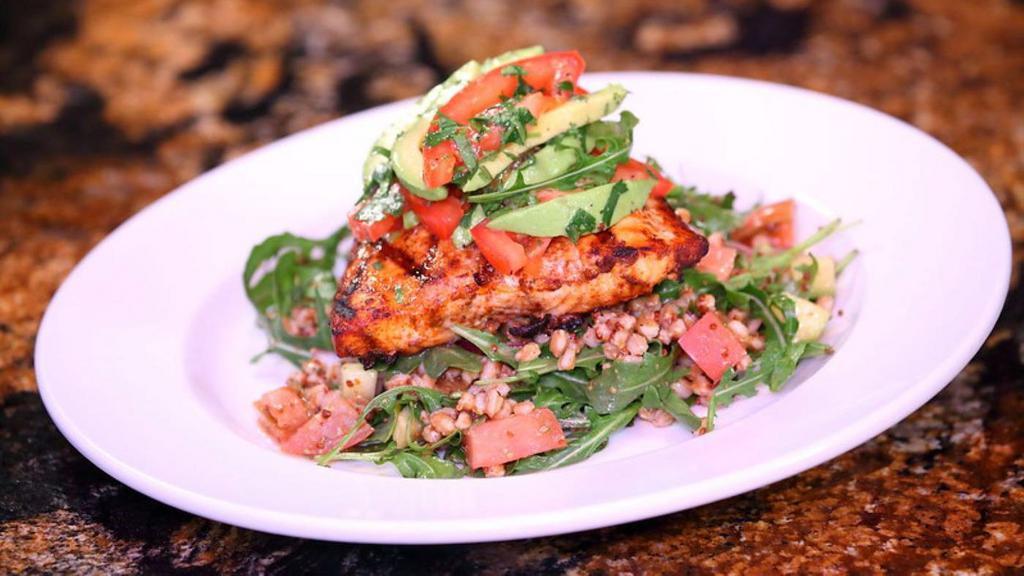 Blackened Salmon · Fresh Atlantic grilled salmon garnished with an avocado salsa, served with arugula salad topped with farro, heirloom tomatoes, cucumber, and red onions, tossed in honey mustard vinaigrette. Under 730 calories.