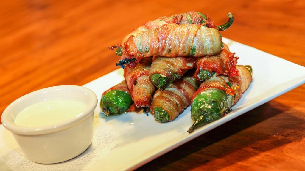 House Made Bacon Wrapped Jalapenos · Cream cheese and spinach stuffed jalapenos, wrapped in bacon and deep fried to perfection. Served with a side of ranch.