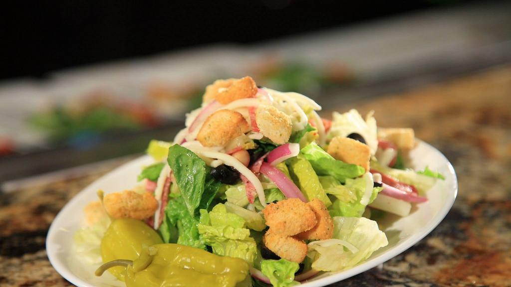 Traditional House Salad · Romaine lettuce, garbanzo beans, olives, salami, red onions, mozzarella cheese, and pepperoncini’s tossed in our creamy Italian vinaigrette.