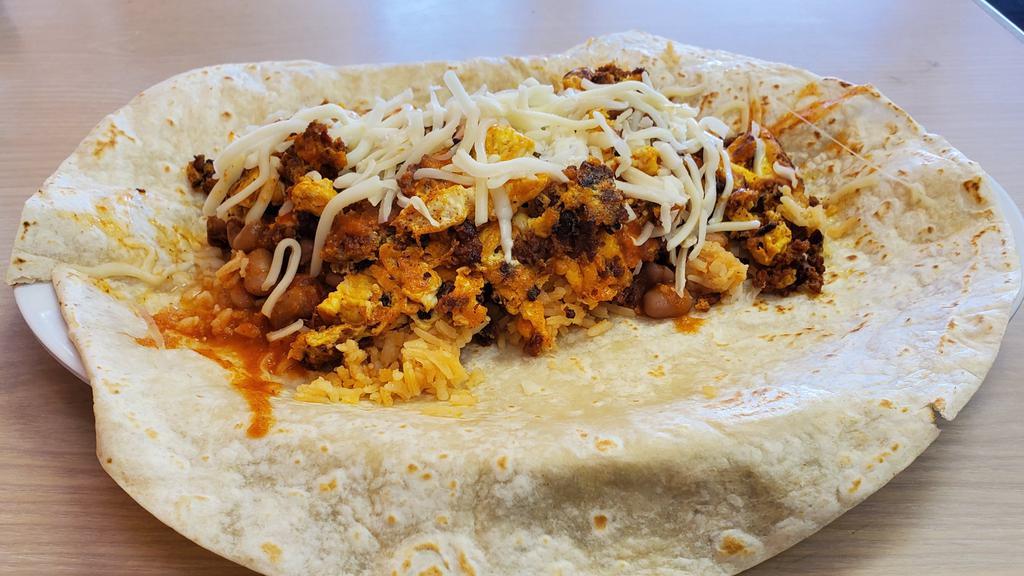 Huevo con Chorizo · Scrambled eggs with chorizo (spiced Mexican pork sausage) served with rice, beans and cheese of hot handmade tortillas.