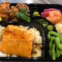 Salmon Teriyaki Bento · Grilled salmon fillet with teriyaki glaze over rice, fried boneless chicken, sashimi, and ed...