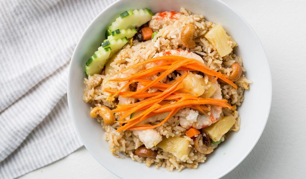 Pineapple Fried Rice · Fried rice with egg, pineapple, veggie shrimp, veggie chicken, cashew nuts, green peas, carrot, onions and raisins.