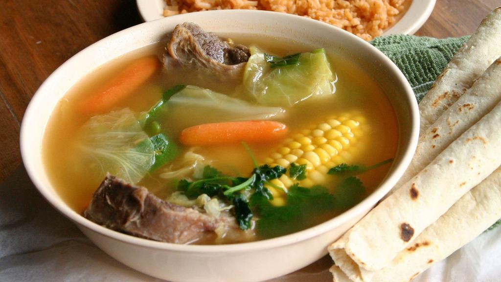 Beef Soup · A generous collection of beef (oxtails, ribs, shanks, knuckles), freshly picked vegetables including zucchini, carrots, corn, yuca, cabbage, onions, cilantro, garlic cooked in a well-seasoned broth.