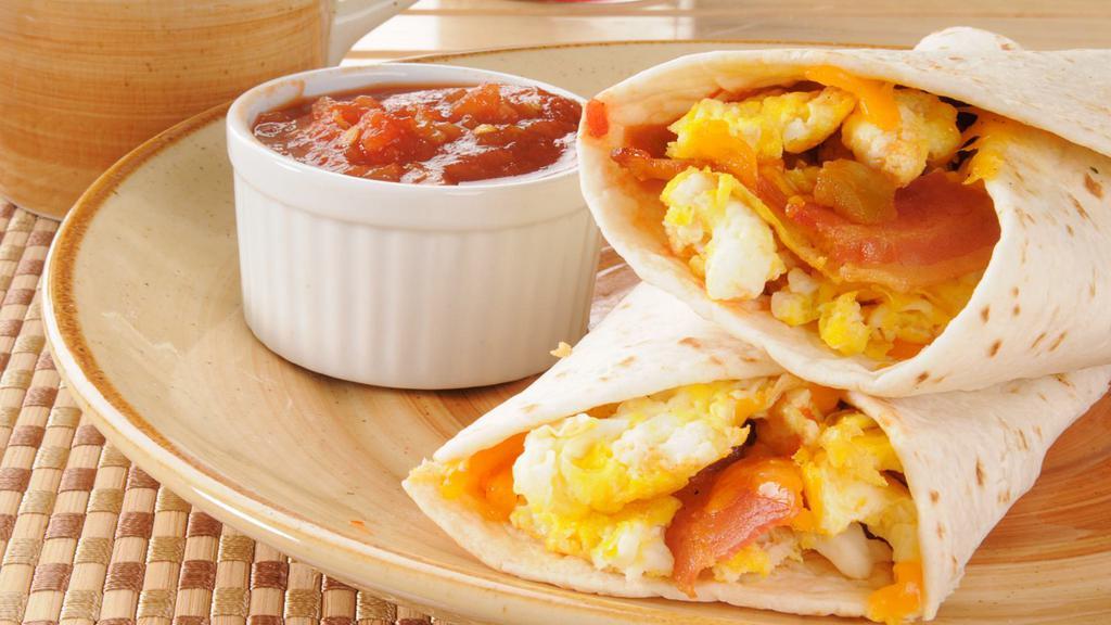 Breakfast Burrito with Bacon · Delicious Breakfast Burrito prepared with a warm flour tortilla filled with Bacon, sautéed bell peppers, onion, grilled potato, salsa, cilantro, cheese, and scrambled eggs. Served with fresh fruit and orange juice.