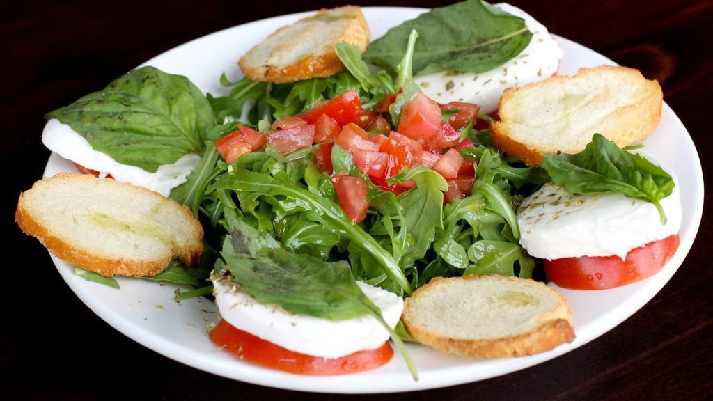 Caprese Salad · Vegetarian. Fresh tomatoes, fresh mozzarella, basil, extra virgin olive oil, balsamic vinegar, and oregano. Served with bread.