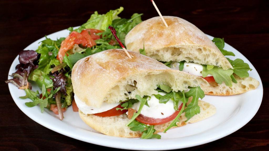 Caprese Sandwich · Vegetarian. Fresh tomatoes, fresh mozzarella, basil, and extra virgin olive oil. Served with mix green and arugula.