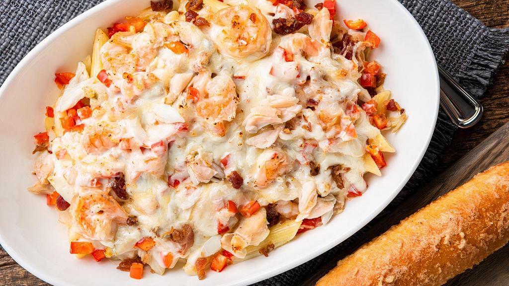 Baked Crab & Shrimp Alfredo · Fresh baked crab, garlic shrimp, diced red bell peppers and bacon over a bed of penne pasta covered in our classic Alfredo sauce and shredded parmesan. Includes one breadstick.