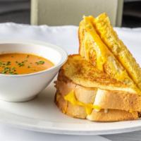 Grilled Cheese and Tomato Soup · Texas toast, cheddar and American cheese, creamy tomato soup, chives.