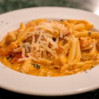 Pollo Alla Bayou · Cajun spiced chicken, Cajun sausage and tomatoes, tossed with penne pasta in a spicy tomato ...
