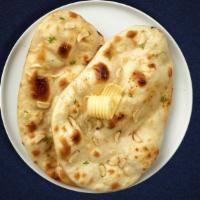 Garlic Manic Naan · Freshly baked bread in a clay oven garnished with garlic and butter
