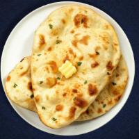 Better Butter Naan · Freshly baked bread in a clay oven garnished with butter