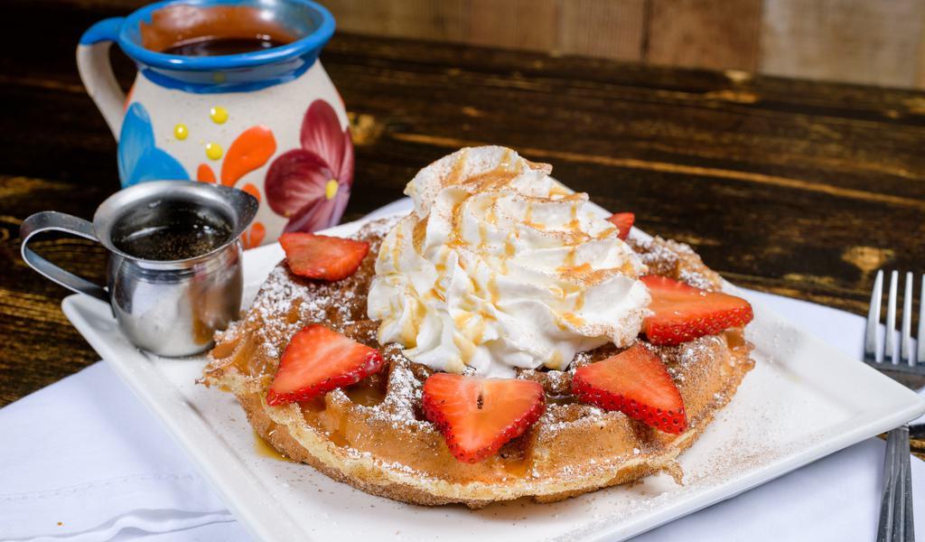 Churro Waffle · Crispy, buttery, cinnamon sugar coated waffle drizzled caramel sauce. Topped with strawberries and whipped cream.