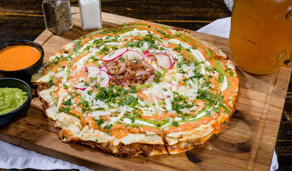 Al Pastor Pizzadilla · Marinated pork, Asadero, Oaxaca, jack cheese, topped w/ avocado sauce, sour cream, chipotle aioli, Chile de arbor sauce, cilantro, onion, pineapple  and radishes.