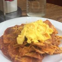 Chilaquiles · Homemade fried corn tortilla strips simmered in salsa rojo, covered with cheese and topped w...