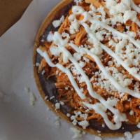 Tostada de Tinga · 1 crispy tostada with a layer of flavorful black beans, chicken tinga (shredded chicken in a...