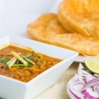 Chana Bhatura · Puffed leanvened bread served with garbanzo beans cooked in special peshawari style gravy.