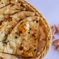 Garlic Naan · Clay oven leavened bread garnished with garlic and herbs.