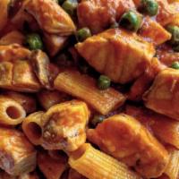 Rigatoni al salmone · Homemade rigatoni pasta with fresh salmon and peas in a light tomato sauce with a touch of c...
