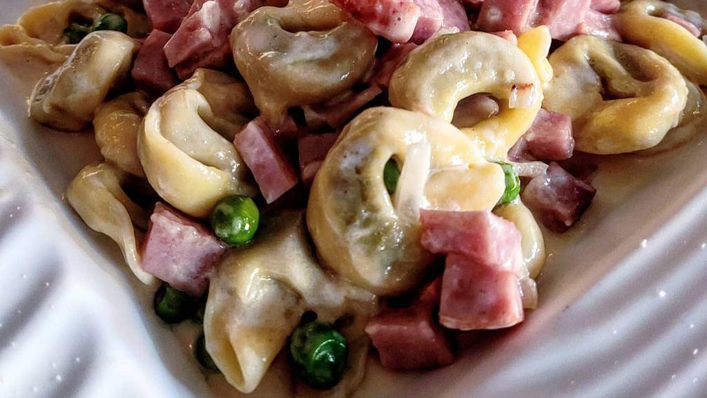Tortellini piselli, panna e prosciutto · Tortellini pasta filled with ground beef and pork, served in cream sauce with peas and imported Italian ham