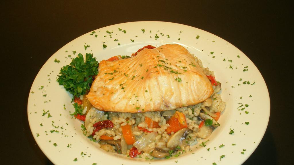 Baked Salmon Risotto · Oven baked salmon served over risotto with onion, artichoke heart, red bell pepper, mushroom, green onion and sun dried tomato.