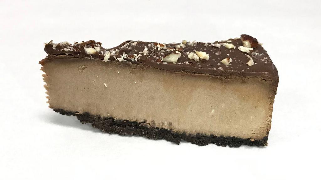 Nutella Cheesecake · Slice of Nutella Cheesecake, topped with Hazelnut pieces.
